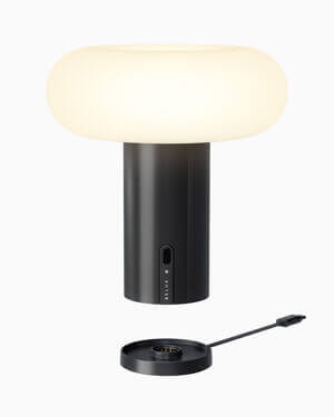 Oto Portable Lampe von Belux mit schwarzem Sockel und rundem, opalweißem Lampenschirm.