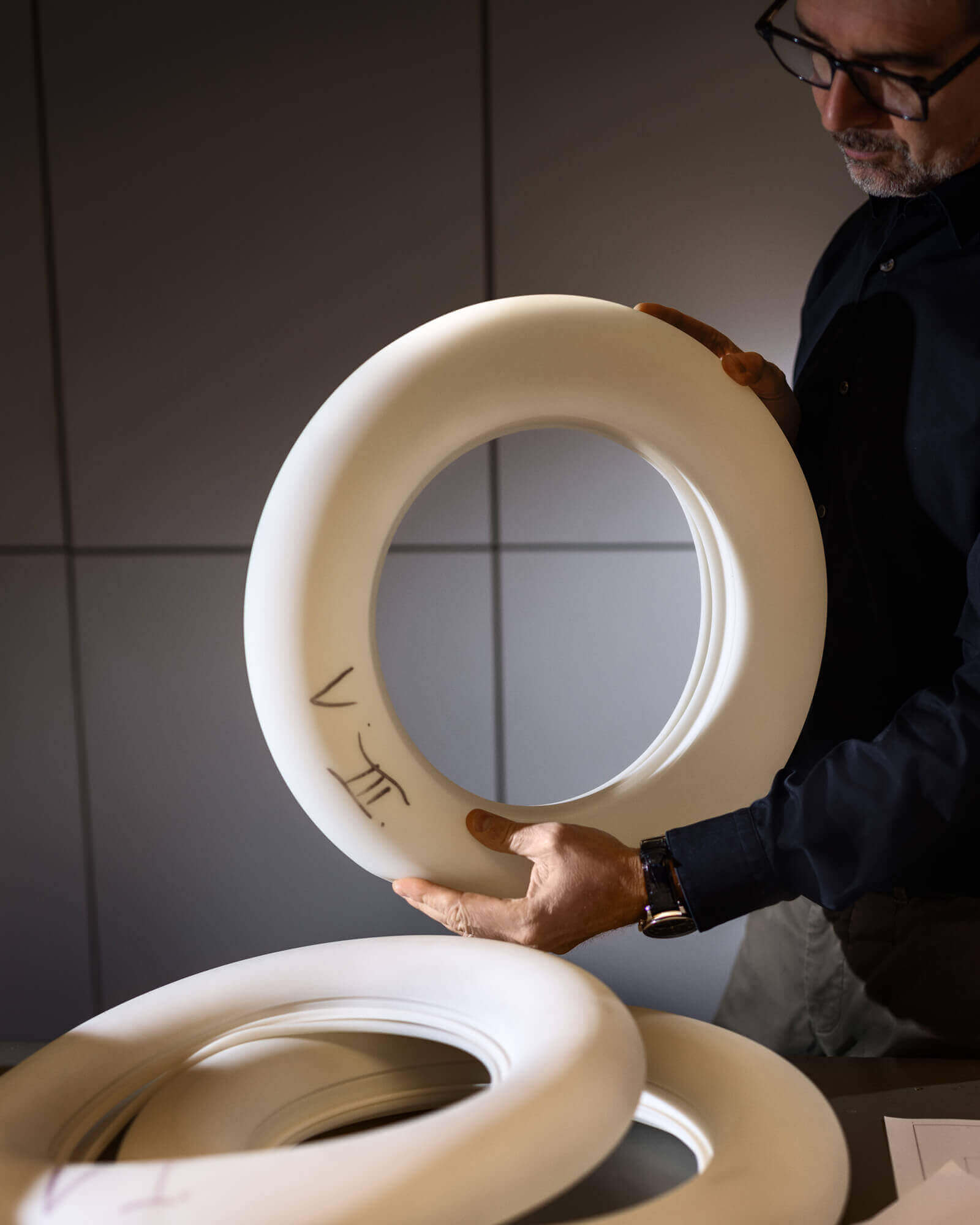 Belux designer holds materials for design in his hand.