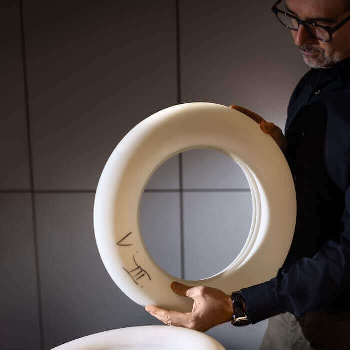 Belux designer holds materials for design in his hand.