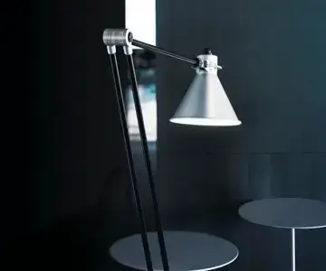 Moderne Tischlampe mit konischem Schirm und schwarzen Standbeinen.