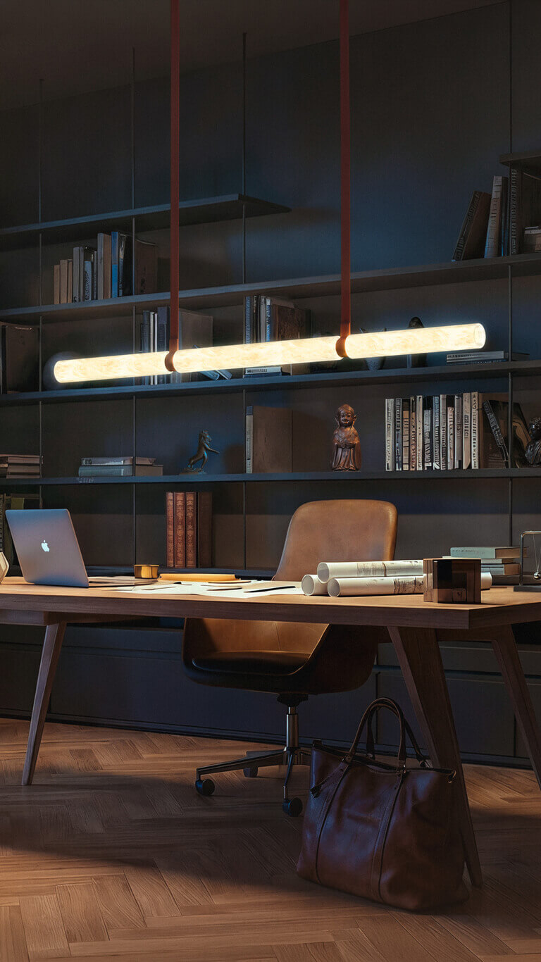 Lineare Pendelleuchte Belux „Equinox“ leuchtet über einem Schreibtisch mit Laptop vor einer dunklen Bücherwand.