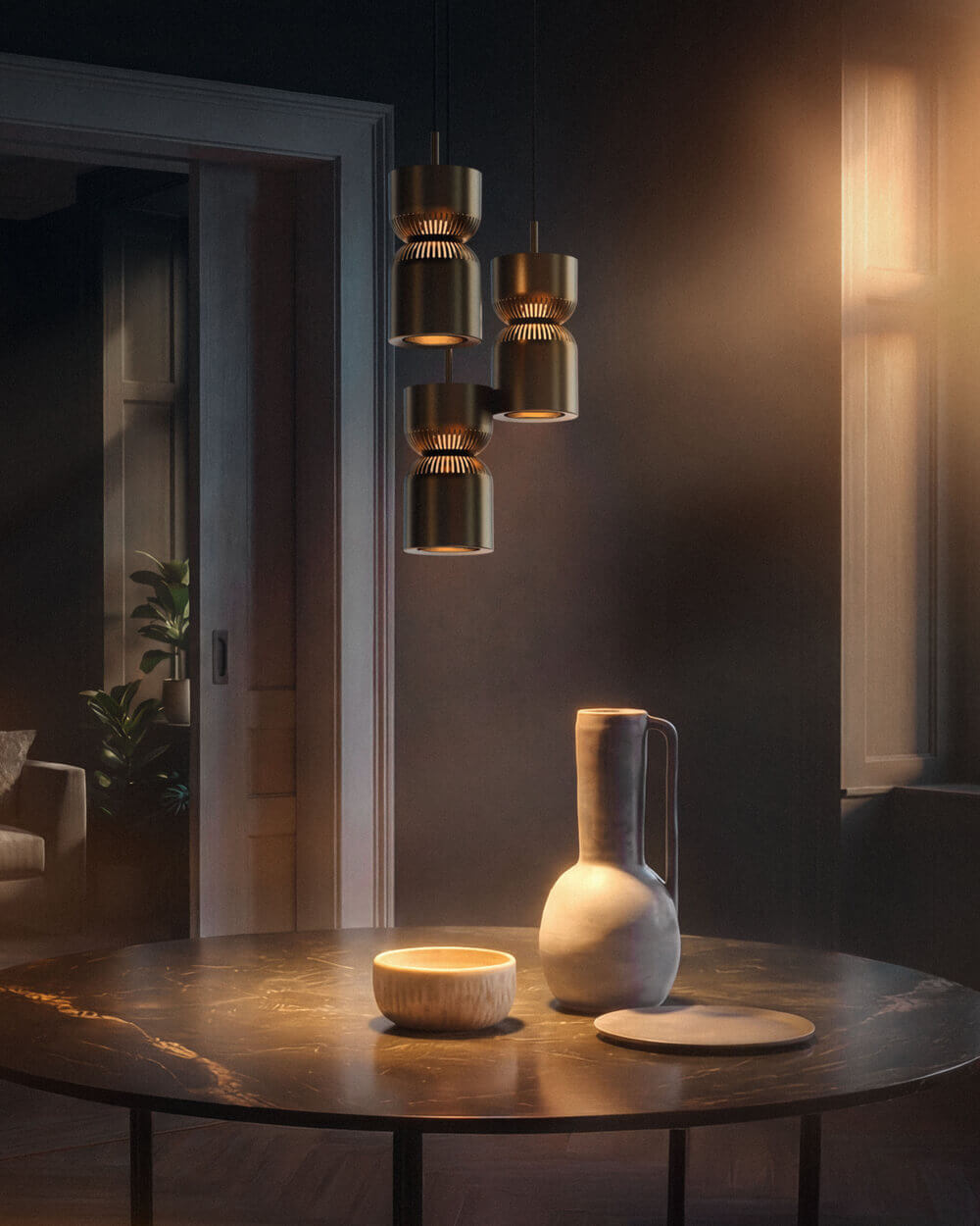 Drei Belux „Moiré“-Pendelleuchten hängen über einem runden Tisch mit Keramikvase und Schale in einem gedämpften Raum.