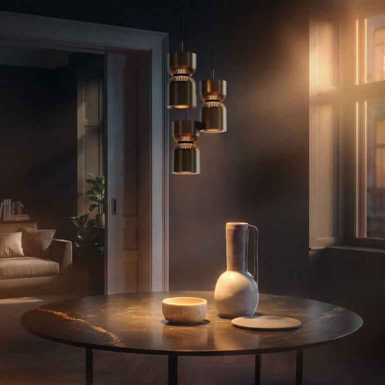 Three Belux "Moiré" pendant lights hang above a round table with a ceramic vase and bowl in a subdued room.